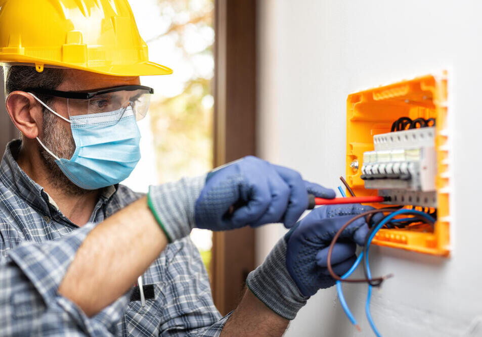 Technician tinkering with an electrical panel