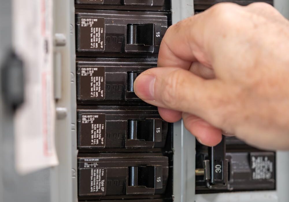 electrician turning off power for electrical outlet